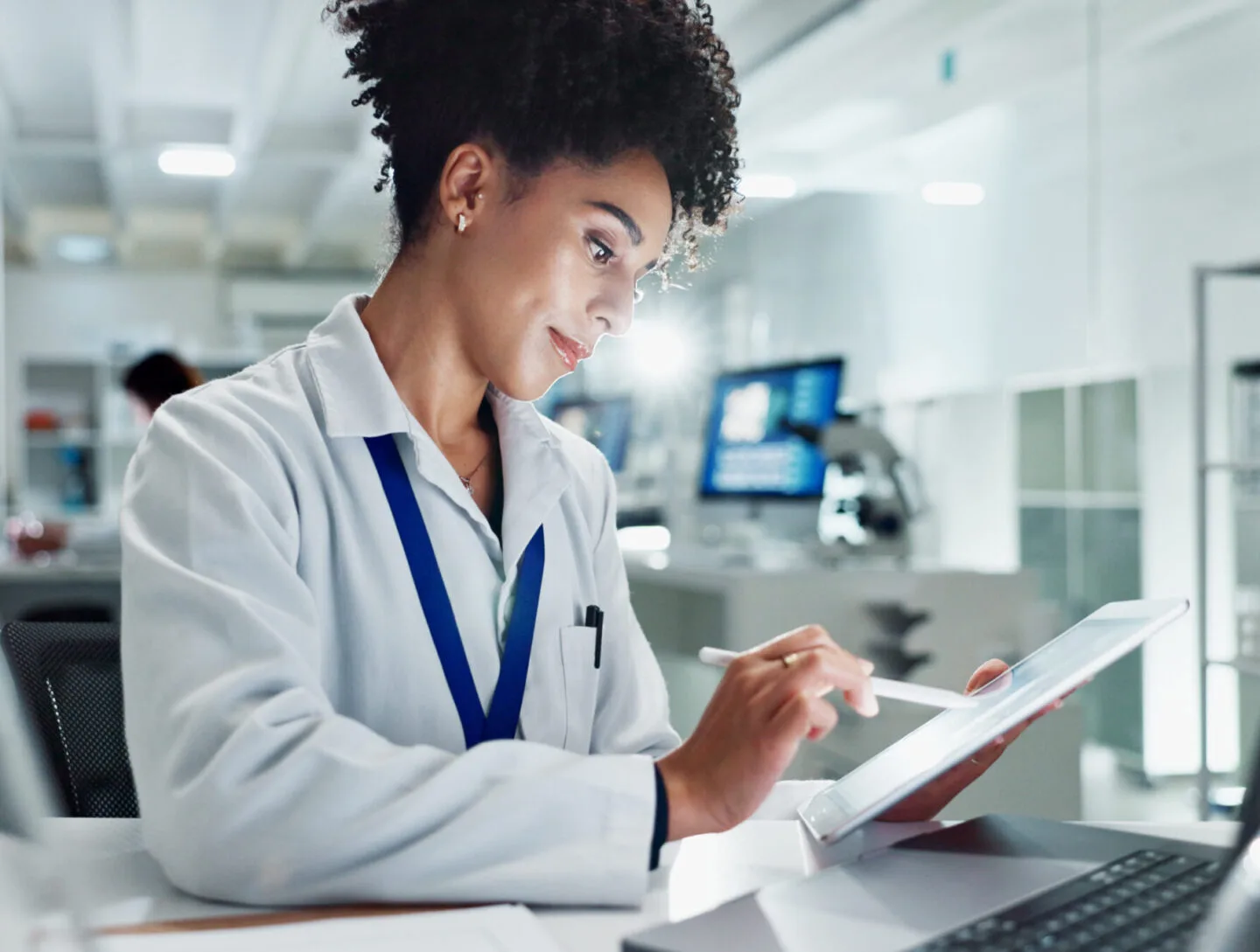 Research scientist reviewing clinical trial data on a tablet in the lab